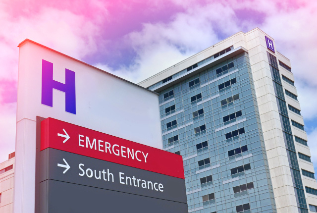 photo of a hospital entrance sign in front of a large medical building