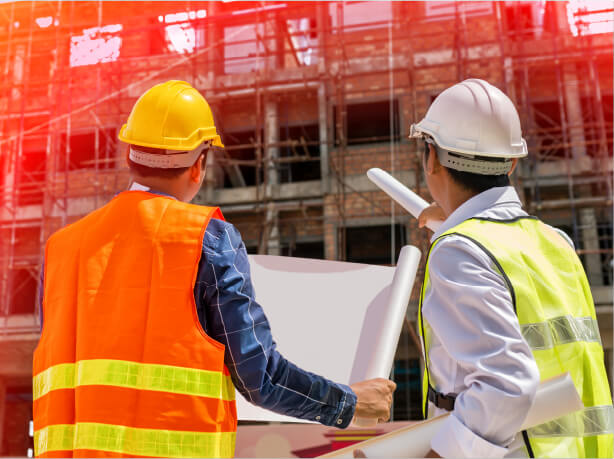 Workers viewing a Hospital being Constructed With Hard Hats